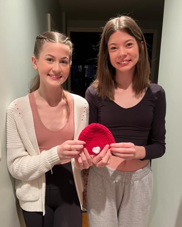 Girls holding knit hat